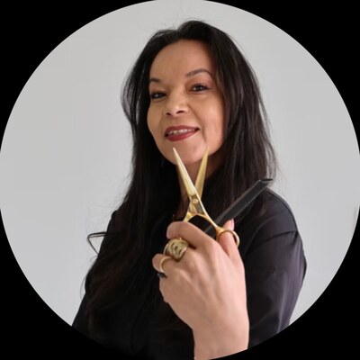 Eva Saturno, founder and lead instructor, holding professional shears and a comb